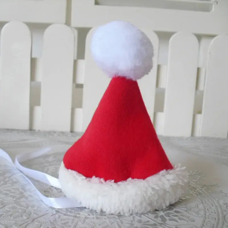 Père Noël bonnet rouge et blanc sur la table - Costume de Noël pour chat festif