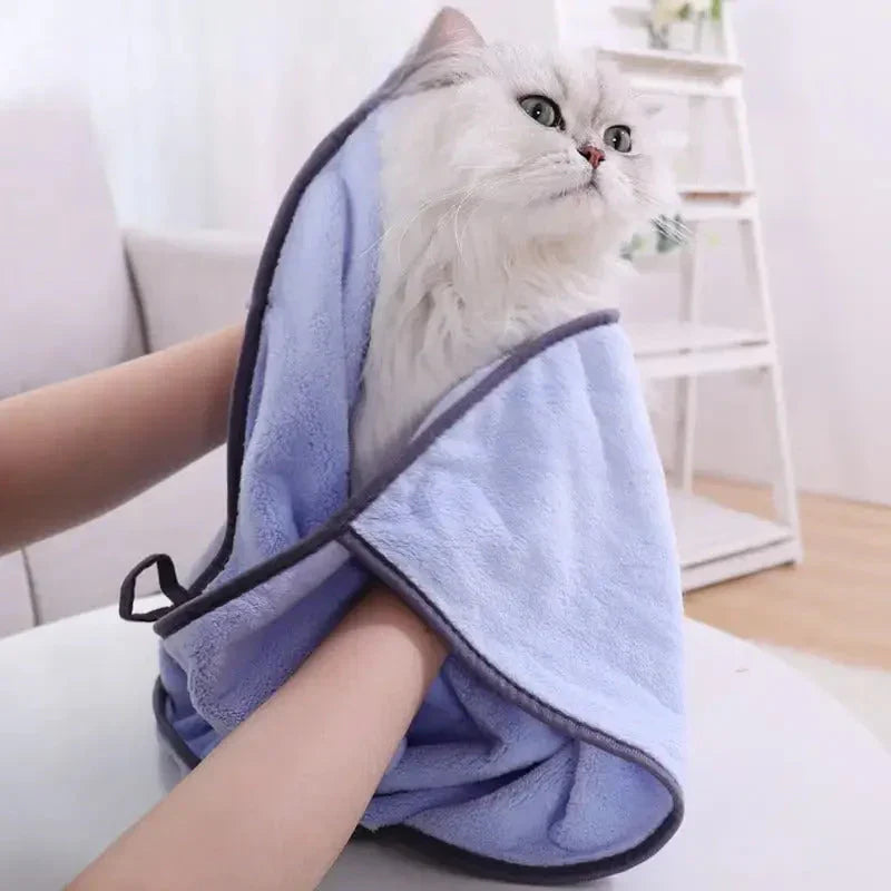 Chat assis sur une serviette de séchage rapide pour chat dans la salle de bain